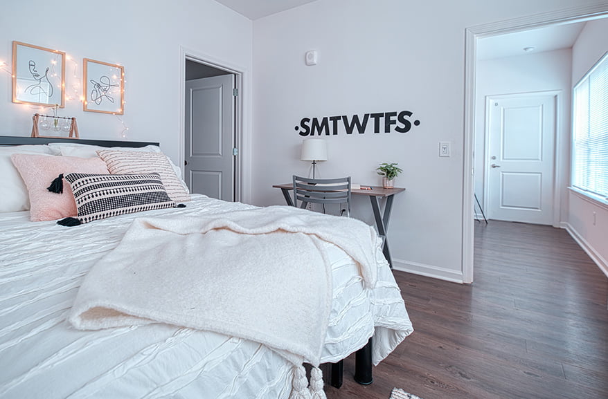 a well kept bedroom with a bed and desk
